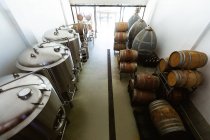 Vue en angle élevé d'un petit compartiment de fermentation et de stockage de brasserie avec cuves et fûts en bois placés le long des murs. — Photo de stock