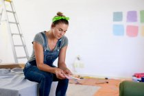Caucasian woman spending time at home self isolating and social distancing in quarantine lockdown during coronavirus covid 19 epidemic, preparing for paint the walls of her house. — Stock Photo