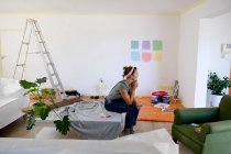 Kaukasische Frau verbringt Zeit zu Hause selbstisolierend und soziale Distanzierung in Quarantäne Lockdown während Coronavirus covid 19 Epidemie, Vorbereitung für die Farbe der Wände ihres Hauses. — Stockfoto