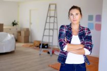 Caucasian woman spending time at home self isolating and social distancing in quarantine lockdown during coronavirus covid 19 epidemic, taking a break while renovating her home, smiling and looking straight into a camera. — Stock Photo