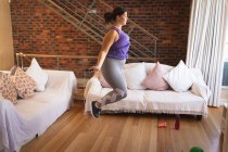 Vlogger mujer caucásica en casa en su sala de estar, demostrando ejercicios con una cuerda de salto para su blog en línea. Distanciamiento social y autoaislamiento en cuarentena. - foto de stock