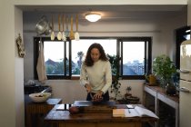 Кавказька жінка проводить вдома самоізоляцію і соціальну дистанцію в карантині під час епідемії коронавірусу 19 років, готуючи їжу на кухні.. — стокове фото