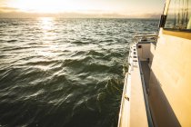 Herrlicher Blick auf Wellen und Sonnenlicht, die sich auf den Wellen des Meeres reflektieren, im Vordergrund ein Fenster des Bootes — Stockfoto