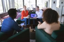 Багатоетнічна група колег по чоловічому та жіночому бізнесу, які працюють в сучасному офісі, зустрічаються в лаунж-зоні, обговорюючи свою роботу — стокове фото