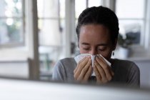 A Caucasian woman spending time at home, blowing her nose. Lifestyle at home isolating, social distancing in quarantine lockdown during coronavirus covid 19 pandemic. — Stock Photo