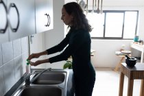Una donna caucasica che passa del tempo a casa a lavarsi le mani. Stile di vita a casa isolante, distanza sociale in isolamento di quarantena durante il coronavirus covid 19 pandemia. — Foto stock