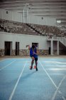 Frontansicht eines gemischten Athleten beim Training in einem Sportstadion, der in Richtung Kamera sprintet. — Stockfoto