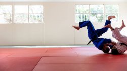 Judocas praticando judô durante um sparring em um ginásio — Fotografia de Stock