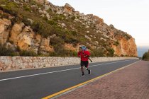 Ein fitter, behinderter Mixed-Race-Athlet mit Beinprothese, der seine Zeit auf einem Ausflug in die Berge, beim Wandern und auf der Straße am Meer genießt. Aktiver Lebensstil mit Behinderung. — Stockfoto