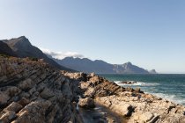 Скелясті прибережні скелі спокійне блакитне море з ясним блакитним небом у сонячний день. Красиві природні пейзажі на узбережжі . — стокове фото