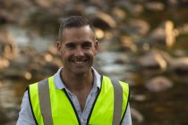 Retrato de feliz caucasiano voluntário de conservação do sexo masculino limpando rio no campo, sorrindo para a câmera. Ecologia e responsabilidade social no meio rural. — Fotografia de Stock