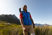 Un atleta maschio di razza mista in forma e disabile con gamba protesica, godendo del suo tempo in un viaggio in montagna, escursioni, passeggiate attraverso l'erba. Stile di vita attivo con disabilità. — Foto stock