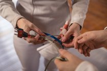 Mid section of sportswoman and sportsman wearing protective fencing outfit during a fencing training session, preparing the body cord before a duel. Fencers training at a gym. — Stock Photo