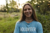 Портрет щасливої кавказької жінки-добровольці, яка займається очищенням лісу в сільській місцевості, посміхається камері. Екологія і соціальна відповідальність в сільському середовищі. — стокове фото