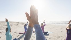 Grupo de amigas caucasianas que gostam de se exercitar em uma praia em um dia ensolarado, praticando ioga e sentado em posição de ioga. — Fotografia de Stock