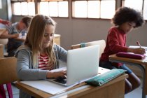 Белая девушка использует ноутбук во время урока. Начальное образование Социальное дистанцирование безопасности здоровья во время пандемии Coronavirus Covid19. — стоковое фото