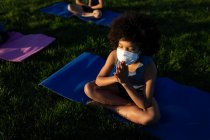 Vista aerea del ragazzo che indossa maschera facciale che esegue yoga nel giardino della scuola. Istruzione primaria distanza sociale sicurezza sanitaria durante la pandemia di Covid19 Coronavirus. — Foto stock