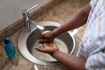 Homem de pé em um banheiro, lavar as mãos, o distanciamento social e auto-isolamento em quarentena bloqueio — Fotografia de Stock