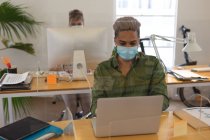 Multi ethnic group of male and female creatives working at office desks with protective screens, using computers. Health and hygiene in workplace during Coronavirus Covid 19 pandemic. — Stock Photo