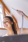 Femme caucasienne passant du temps à la maison, dans la salle de bain, se lavant les cheveux sous la douche. Distance sociale pendant le confinement en quarantaine du coronavirus Covid 19. — Photo de stock