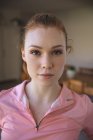 Portrait of attractive, ginger Caucasian woman spending time at home, in living room, wearing sportswear. Social distancing during Covid 19 Coronavirus quarantine lockdown. — Stock Photo