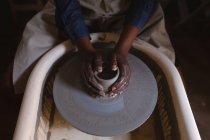 Female potter working in pottery studio. working at a potters wheel. small creative business during covid 19 coronavirus pandemic. — Stock Photo