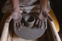 Female potter working in pottery studio. working at a potters wheel. small creative business during covid 19 coronavirus pandemic. — Stock Photo