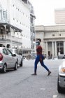 Mulher afro-americana usando máscara facial andando na rua. fora e sobre na cidade durante covid 19 coronavirus pandemia. — Fotografia de Stock