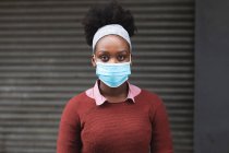 Porträt einer Afroamerikanerin, die während der 19. Coronavirus-Pandemie in der Stadt in die Kamera schaut. — Stockfoto