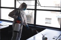 Trabalhador de saúde vestindo roupas de proteção escritório de limpeza usando desinfetante. limpeza e desinfecção prevenção de infecção e controle da epidemia de covid-19 — Fotografia de Stock