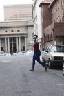 Afro-americano donna indossare faccia maschera a piedi su strada fuori e in giro per la città durante covid 19 coronavirus pandemia. — Foto stock