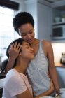 Happy mixed race female couple embracing in kitchen in the morning. self isolation quality time at home together during coronavirus covid 19 pandemic. — Stock Photo