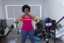 Vlogger afroamericana grabando un video. sobre el ejercicio. auto aislamiento tecnología comunicación en el hogar durante coronavirus covid 19 pandemia. - foto de stock