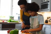 Mulher de raça mista e filha preparando comida na cozinha. auto isolamento tempo familiar de qualidade em casa juntos durante coronavírus covid 19 pandemia. — Fotografia de Stock