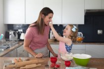 Mãe e filha caucasiana se divertindo cozinhando na cozinha. desfrutando de tempo de qualidade em casa durante coronavírus covid 19 bloqueio pandêmico. — Fotografia de Stock