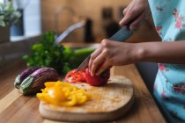 Mujer picando verduras en la cocina. autoaislamiento calidad familia tiempo en casa juntos durante coronavirus covid 19 pandemia. - foto de stock