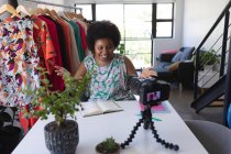 Afroamerikanische Vloggerin nimmt ein Video im Kleiderschrank auf. Schreiben in Notizbuch. Selbstisolation Technologie Kommunikation zu Hause während Coronavirus covid 19 Pandemie. — Stockfoto