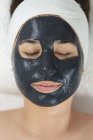 Femme blanche allongée pendant que l'esthéticienne applique un masque facial. client bénéficiant d'un traitement dans un salon de beauté. — Photo de stock