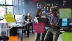 Diversi uomini e donne che lavorano in ufficio creativo, utilizzando laptop sorridente. ufficio moderno lavoro di squadra brainstorming. — Foto stock