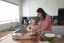 Mère et fille caucasiennes s'amusent à cuisiner dans la cuisine. profiter d'un temps de qualité à la maison pendant le confinement de coronavirus covid 19 pandémie. — Photo de stock