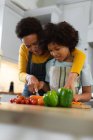 Mixed race woman and daughter preparing food in kitchen. self isolation quality family time at home together during coronavirus covid 19 pandemic. — Stock Photo
