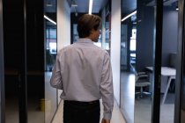 Uomo d'affari caucasico che cammina con un portatile in un ufficio moderno. affari ufficio moderno tecnologia sul posto di lavoro. — Foto stock