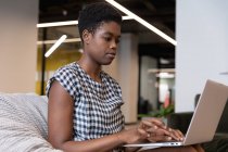 Mulher de negócios de raça mista sentado usando laptop em um escritório moderno. negócio moderno escritório tecnologia do local de trabalho. — Fotografia de Stock
