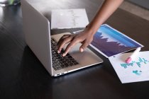 Бізнес-леді, що стоїть за допомогою ноутбука, що проходить через паперові роботи в сучасному офісі. бізнес сучасні технології офісного робочого місця . — стокове фото
