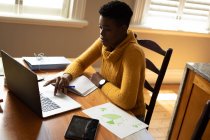 Afroamerikanerin benutzt Laptop, während sie von zu Hause aus arbeitet. Zu Hause bleiben in Selbstisolierung in Quarantäne — Stockfoto