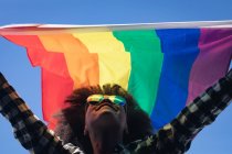 Gemischte Frau mit Regenbogenfahne auf dem Dach. Geschlecht fluid lgbt Identität rassische Gleichberechtigung Konzept. — Stockfoto