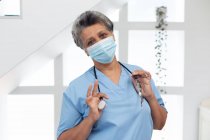 Portrait of senior african american female doctor wearing a face mask looking at the camera. healthcare hygiene protection during coronavirus covid 19 pandemic. — Stock Photo