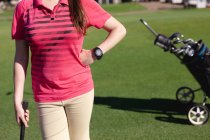 Sezione centrale di donna in piedi su un campo da golf con una mazza da golf. sport tempo libero hobby golf sano stile di vita all'aperto. — Foto stock