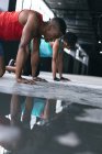 Uomini e donne afroamericani che indossano vestiti sportivi facendo flessioni in un edificio urbano vuoto. fitness urbano stile di vita sano. — Foto stock