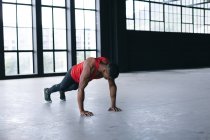 Homem afro-americano vestindo roupas esportivas fazendo flexões em prédio urbano vazio. fitness urbano estilo de vida saudável. — Fotografia de Stock
